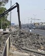 PWD desilts a drain near West Vinod Nagar and leave silt on the road near NH24 in April. (Sanjeev Verma/HT Photo)