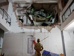 A police officer stands in front of debris at the crash site after an Air India aircraft, bound for London's Gatwick Airport, crashed during take-off from an airport in Ahmedabad.