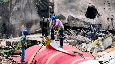 A crane lifts the wreckage of the crashed Air India plane from the roof of BJ Medical College mess on Saturday. (Raju Shinde/HT)
