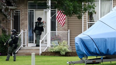 Officers canvas the neighborhood after what police said was a targeted shooting in the area around Edinburgh Golf Course in the Minneapolis suburb of Brooklyn Park, Minnesota. (REUTERS)