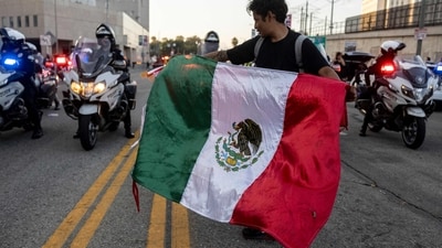 A demonstrator waves a Mexican flag in front of Los Angeles Police (LAPD) officer on motorbikes in front of the Metropolitan Detention Center as protests continue in response to federal immigration operations in Los Angeles on June 13, 2025. A judge has ordered Donald Trump to return control of the California National Guard to the state, saying the president's decision to deploy them to protest-hit Los Angeles over Governor Gavin Newsom's objections was "illegal." Protests against Donald Trump's harsh immigration policies spread on June 11 across the United States despite a military-backed crackdown in Los Angeles and threats by the hard-right Republican president to use "heavy force." (Photo by ETIENNE LAURENT / AFP) (AFP) A demonstrator waves a Mexican flag in front of Los Angeles Police (LAPD) officer on motorbikes in front of the Metropolitan Detention Center as protests continue in response to federal immigration operations in Los Angeles on June 13, 2025. A judge has ordered Donald Trump to return control of the California National Guard to the state, saying the president's decision to deploy them to protest-hit Los Angeles over Governor Gavin Newsom's objections was "illegal." Protests against Donald Trump's harsh immigration policies spread on June 11 across the United States despite a military-backed crackdown in Los Angeles and threats by the hard-right Republican president to use "heavy force." (Photo by ETIENNE LAURENT / AFP) (AFP)