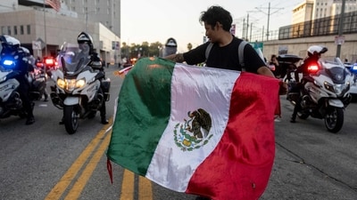 A demonstrator waves a Mexican flag in front of Los Angeles Police (LAPD) officer on motorbikes in front of the Metropolitan Detention Center as protests continue in response to federal immigration operations in Los Angeles on June 13, 2025. (AFP) A demonstrator waves a Mexican flag in front of Los Angeles Police (LAPD) officer on motorbikes in front of the Metropolitan Detention Center as protests continue in response to federal immigration operations in Los Angeles on June 13, 2025. (AFP)