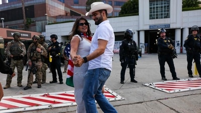 A couple dances in front of law enforcement during protests outside of a federal building and Immigration and Customs Enforcement (ICE) detention center on June 13, 2025, in Los Angeles, California. (Getty Images via AFP) A couple dances in front of law enforcement during protests outside of a federal building and Immigration and Customs Enforcement (ICE) detention center on June 13, 2025, in Los Angeles, California. (Getty Images via AFP)
