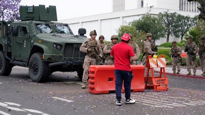 A man wearing a 'Make America Great Again' cap speaks to U.S. Marines in front of the Wilshire Federal Building, after they were deployed to Los Angeles as federal immigration sweeps continue, in Los Angeles, California, U.S., June 13, 2025. REUTERS/David Ryder (REUTERS)