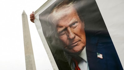 A supporter of U.S President Donald Trump holds a banner with his picture near the Washington Monument, ahead of the upcoming U.S. Army 250th anniversary celebration parade, in Washington, D.C., U.S., June 13, 2025. REUTERS/Nathan Howard (REUTERS)