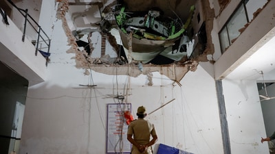 A police officer stands in front of debris at the crash site after an Air India aircraft, bound for London's Gatwick Airport, crashed during take-off from an airport in Ahmedabad. (Reuters)