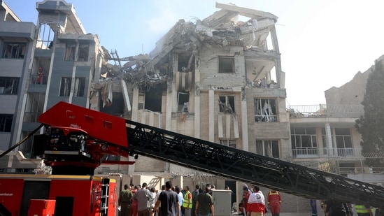 Rescue teams work outside a heavily damaged building, targeted by an Israeli strike in the Iranian capital Tehran.(AFP)