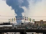 Flags flutter along a bridge as a plume of heavy smoke and fire rise from an oil refinery in southern Tehran, after it was hit in an overnight Israeli strike. Flags flutter along a bridge as a plume of heavy smoke and fire rise from an oil refinery in southern Tehran, after it was hit in an overnight Israeli strike.