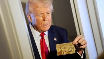 President Donald Trump holds up the $5 million gold card as he speaks to reporters while in flight on board Air Force One. (AP) President Donald Trump holds up the $5 million gold card as he speaks to reporters while in flight on board Air Force One. (AP)