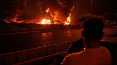 A man looks at flames rising from an oil storage facility after it appeared to have been struck by an Israeli strike in Tehran, Iran, early Sunday, June 15, 2025. (AP) A man looks at flames rising from an oil storage facility after it appeared to have been struck by an Israeli strike in Tehran, Iran, early Sunday, June 15, 2025. (AP)