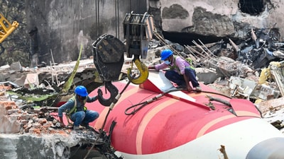 The wreckage of the crashed Air India plane is being lifted by a crane from the roof of the BJ Medical College mess building. (HT Photo) The wreckage of the crashed Air India plane is being lifted by a crane from the roof of the BJ Medical College mess building. (HT Photo)