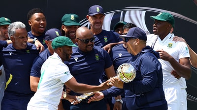 South Africa's Temba Bavuma passes the ICC Test Championship Mace to head coach Shukri Conrad as they celebrate on the podium. (Action Images via Reuters)