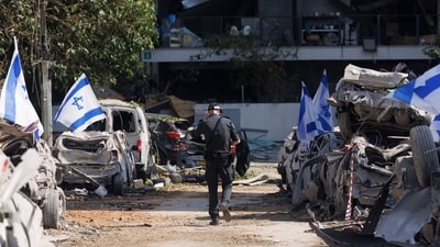 Israeli flags placed on vehicles destroyed in an overnight a ballistic missile attack by Iran, in Ramat Gan, Israel, on Saturday. (Bloomberg) Israeli flags placed on vehicles destroyed in an overnight a ballistic missile attack by Iran, in Ramat Gan, Israel, on Saturday. (Bloomberg)