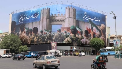 Iranians drive past an anti-Israel poster in Tehran's Enghlab Square on June 14, 2025. Israel's military said that its fighter jets were set to resume striking targets in Tehran, after announcing it had hit air defences in the Iranian capital area overnight, as Israel and Iran trade fire with such intensity for the first time following decades of enmity and conflict by proxy, with fears of a prolonged conflict engulfing the region. (Atta Kenare/AFP) Iranians drive past an anti-Israel poster in Tehran's Enghlab Square on June 14, 2025. Israel's military said that its fighter jets were set to resume striking targets in Tehran, after announcing it had hit air defences in the Iranian capital area overnight, as Israel and Iran trade fire with such intensity for the first time following decades of enmity and conflict by proxy, with fears of a prolonged conflict engulfing the region. (Atta Kenare/AFP)
