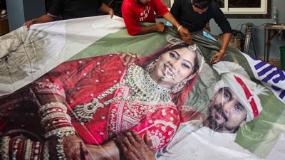 Raja Raghuvanshi's family members, cut out the picture of his wife Sonam Raghuvanshi from a poster of their marriage after she was accused of plotting Raja's murder in Meghalaya, in Indore, (PTI) Raja Raghuvanshi's family members, cut out the picture of his wife Sonam Raghuvanshi from a poster of their marriage after she was accused of plotting Raja's murder in Meghalaya, in Indore, (PTI)