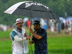 J.J. Spaun seeks shelter from the rain under an umbrella with his caddie, Mark Carens J.J. Spaun seeks shelter from the rain under an umbrella with his caddie, Mark Carens