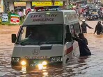 People push an ambulance while wading through a waterlogged road amid rainfall, in Mangaluru, Karnataka. People push an ambulance while wading through a waterlogged road amid rainfall, in Mangaluru, Karnataka.