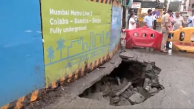 A portion of the road near Girgaon Metro Station in Mumbai caved in today. A BEST bus got stuck in the caved-in portion. Latest visuals from the site. (Screengrab from X/@ANI)