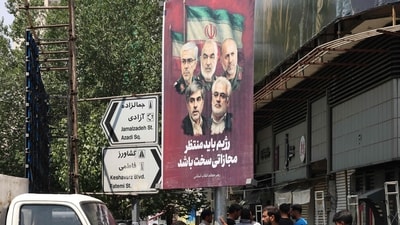 A poster displaying the portraits of Iranian military generals and nuclear scientists, killed in Israel's attack early on June 13, hangs from a lamppost in Tehran on June 14, 2025. (AFP)