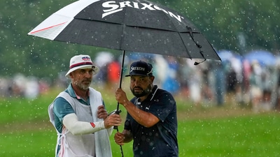 J.J. Spaun seeks shelter from the rain under an umbrella with his caddie, Mark Carens (AP) J.J. Spaun seeks shelter from the rain under an umbrella with his caddie, Mark Carens (AP)