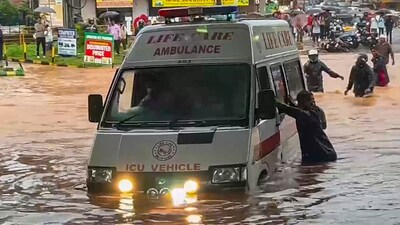 People push an ambulance while wading through a waterlogged road amid rainfall, in Mangaluru, Karnataka. (PTI) People push an ambulance while wading through a waterlogged road amid rainfall, in Mangaluru, Karnataka. (PTI)