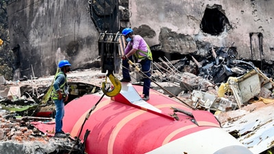 The wreckage of the crashed Air India plane being lifted by a crane from the roof of the BJ Medical College mess building. (HT PHOTO)