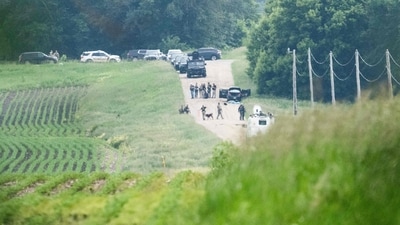 Law enforcement search the area around a vehicle on 301st Avenue on June 15, 2025 in Belle Plaine, Minnesota (Getty Images via AFP)