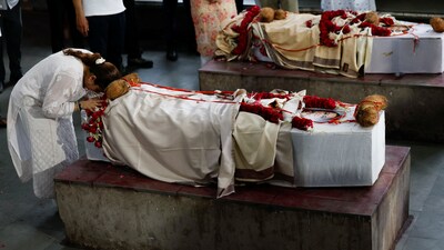 Meena Patel's daughter bows over her mother’s coffin, after Meena died in the Air India Boeing 787-8 Dreamliner plane crash during take-off from Ahmedabad airport (REUTERS)