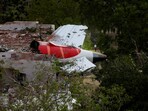 Tail of an Air India Boeing 787 Dreamliner plane that crashed is seen stuck on a building after the incident in Ahmedabad.