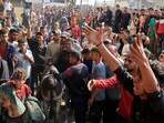 People react as Palestinian casualties, who were waiting to receive aid, are brought into Nasser hospital in Gaza following an Israeli strike, according to the Gaza Health Ministry.