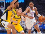 Oklahoma City Thunder guard Aaron Wiggins, right, drives as Indiana Pacers guard T.J. McConnell (9) and center Tony Bradley (13) defend during the first half of Game 5 of the NBA Finals basketball series.