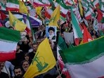 Demonstrators wave Iranian and Hezbollah flags as one holds up a poster of Iran's Supreme Leader Ayatollah Ali Khamenei Demonstrators wave Iranian and Hezbollah flags as one holds up a poster of Iran's Supreme Leader Ayatollah Ali Khamenei