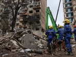 Rescuers with service dogs prepare to look for residents, who could still be under the rubble of a destroyed apartment building, which was hit during a Russian missile strike in Kyiv