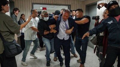The incident's video, which was shared on X, shows Lander outside a courtroom as masked police officers approach him. (AP) The incident's video, which was shared on X, shows Lander outside a courtroom as masked police officers approach him. (AP)