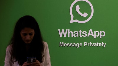 FILE PHOTO: A woman uses her phone next to a logo of the WhatsApp application during Global Fintech Fest in Mumbai. (REUTERS)