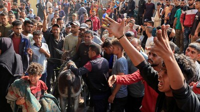 People react as Palestinian casualties, who were waiting to receive aid, are brought into Nasser hospital in Gaza following an Israeli strike, according to the Gaza Health Ministry. (REUTERS)