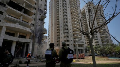 Israeli security forces inspect a residential building hit by a missile launched from Iran in Petah Tikva, Israel. (AP)