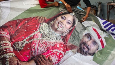 Raja Raghuvanshi's family members cutting out the picture of his wife Sonam Raghuvanshi from a poster of their marriage after she was accused of plotting Raja's murder in Meghalaya, in Indore, (PTI)
