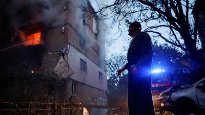A resident looks at an apartment building in Kyiv damaged during a Russian strike on Ukraine on June 17. (REUTERS)