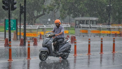 A commuter passes through during heavy rainfall, in New Delhi on Sunday. (ANI ) A commuter passes through during heavy rainfall, in New Delhi on Sunday. (ANI )
