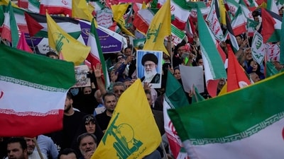 Demonstrators wave Iranian and Hezbollah flags as one holds up a poster of Iran's Supreme Leader Ayatollah Ali Khamenei (AP) Demonstrators wave Iranian and Hezbollah flags as one holds up a poster of Iran's Supreme Leader Ayatollah Ali Khamenei (AP)