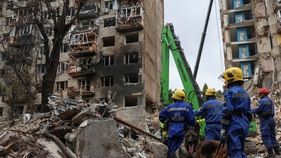 Rescuers with service dogs prepare to look for residents, who could still be under the rubble of a destroyed apartment building, which was hit during a Russian missile strike in Kyiv (REUTERS)