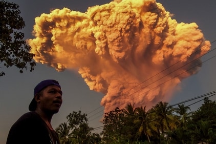 TOPSHOT - A villager watches the eruption of Mount Lewotobi Laki-Laki as seen from Talibura village in Sikka, East Nusa Tenggara, on June 17, 2025. A volcano in eastern Indonesia spewed a colossal ash tower into the sky on June 17, authorities said, after they raised its alert level to the highest of a four-tiered system. (Photo by AFP) (AFP) TOPSHOT - A villager watches the eruption of Mount Lewotobi Laki-Laki as seen from Talibura village in Sikka, East Nusa Tenggara, on June 17, 2025. A volcano in eastern Indonesia spewed a colossal ash tower into the sky on June 17, authorities said, after they raised its alert level to the highest of a four-tiered system. (Photo by AFP) (AFP)