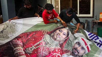 Raja Raghuvanshi's family members, cut out the picture of his wife Sonam Raghuvanshi from a poster of their marriage after she was accused of plotting Raja's murder in Meghalaya, in Indore. (PTI) Raja Raghuvanshi's family members, cut out the picture of his wife Sonam Raghuvanshi from a poster of their marriage after she was accused of plotting Raja's murder in Meghalaya, in Indore. (PTI)