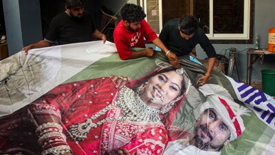 Raja Raghuvanshi's family members, cut out the picture of his wife Sonam Raghuvanshi from a poster of their marriage. (PTI) Raja Raghuvanshi's family members, cut out the picture of his wife Sonam Raghuvanshi from a poster of their marriage. (PTI)