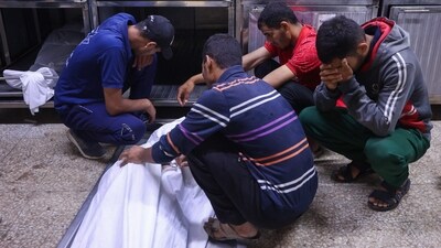 People mourn by the body of Palestinians who were killed a day earlier in Israeli fire while seeking food aid, at Al-Shifa hospital morgue in Gaza City (AFP) People mourn by the body of Palestinians who were killed a day earlier in Israeli fire while seeking food aid, at Al-Shifa hospital morgue in Gaza City (AFP)