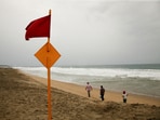 A red flag flutters in the wind, warning beachgoers of dangerous conditions as Hurricane Erick strengthens off Mexico's Pacific Coast, in Puerto Escondido, Oaxaca state, Mexico, June 18, 2025. 
