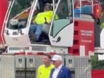 Unaware of the situation behind him, Donald Trump continued chatting with workers and admiring the structures. Unaware of the situation behind him, Donald Trump continued chatting with workers and admiring the structures.