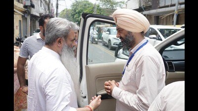 Congress candidate Bharat Bhushan Ashu interacting with Shiromani Akali Dal candidate Parupkar Singh Ghuman outside a polling booth in Ludhiana on Thursday. (Gurpreet Singh/HT) Congress candidate Bharat Bhushan Ashu interacting with Shiromani Akali Dal candidate Parupkar Singh Ghuman outside a polling booth in Ludhiana on Thursday. (Gurpreet Singh/HT)