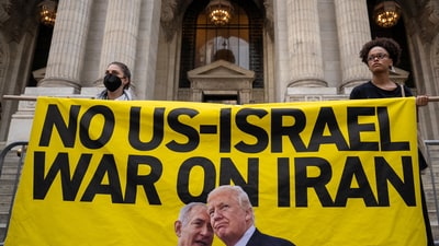 Protesters hold a banner with a message and images of U.S. President Donald Trump and Israeli Prime Minister Benjamin Netanyahu during a 'No War on Iran' rally in New York City, U.S., June 18, 2025. (REUTERS)